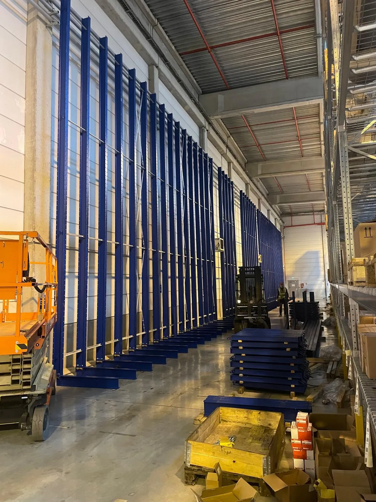Zicht door de magazijngang met palletstellingen links en de draagarmstelling rechts