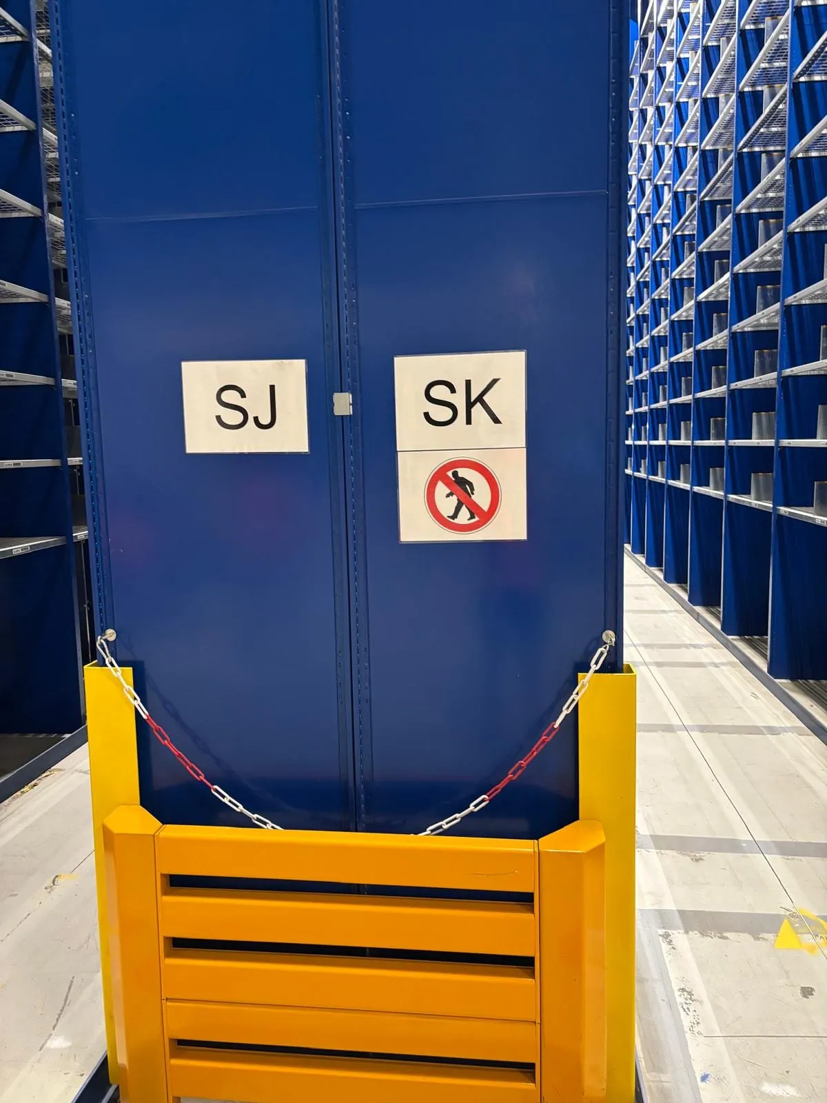 Blauw kopschot met de gangletters SJ en SK, afgeschermd met gele aanrijdbeveiliging en een ketting