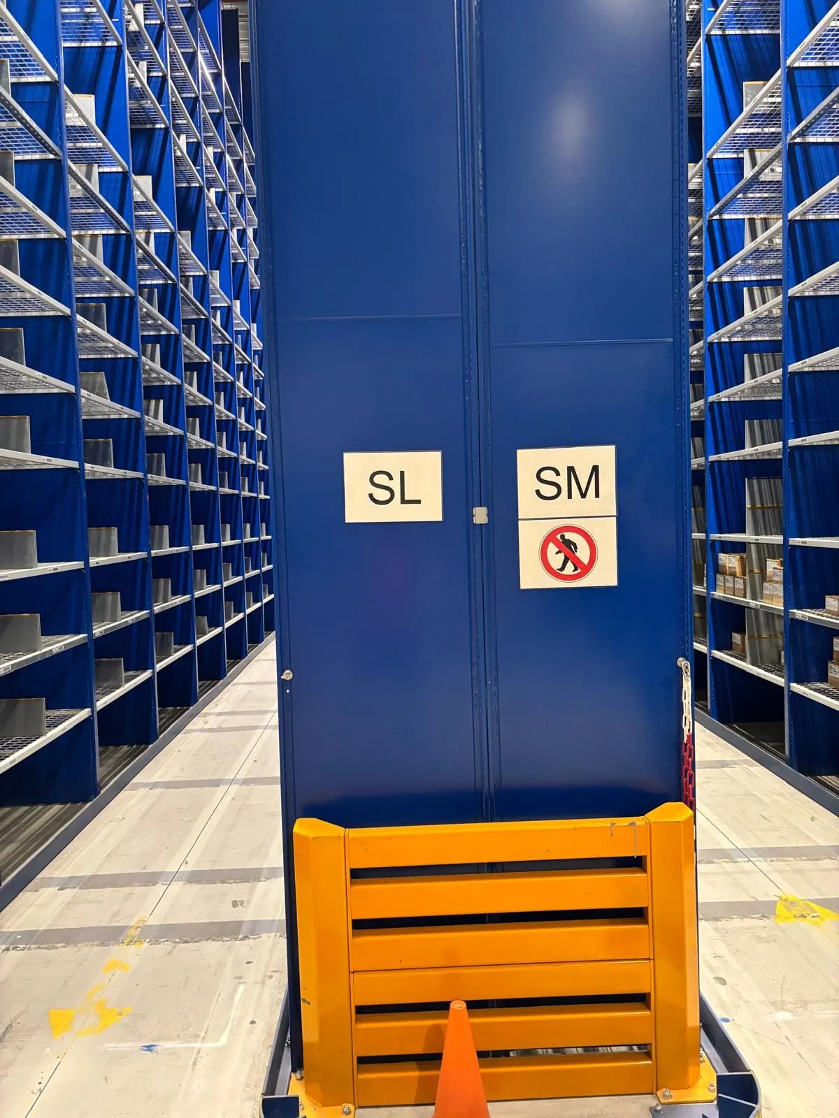 Kopschot met de gangletters SL en SM en gele aanrijdbeveiliging, met aan weerszijden een gang tussen de legbordstellingen