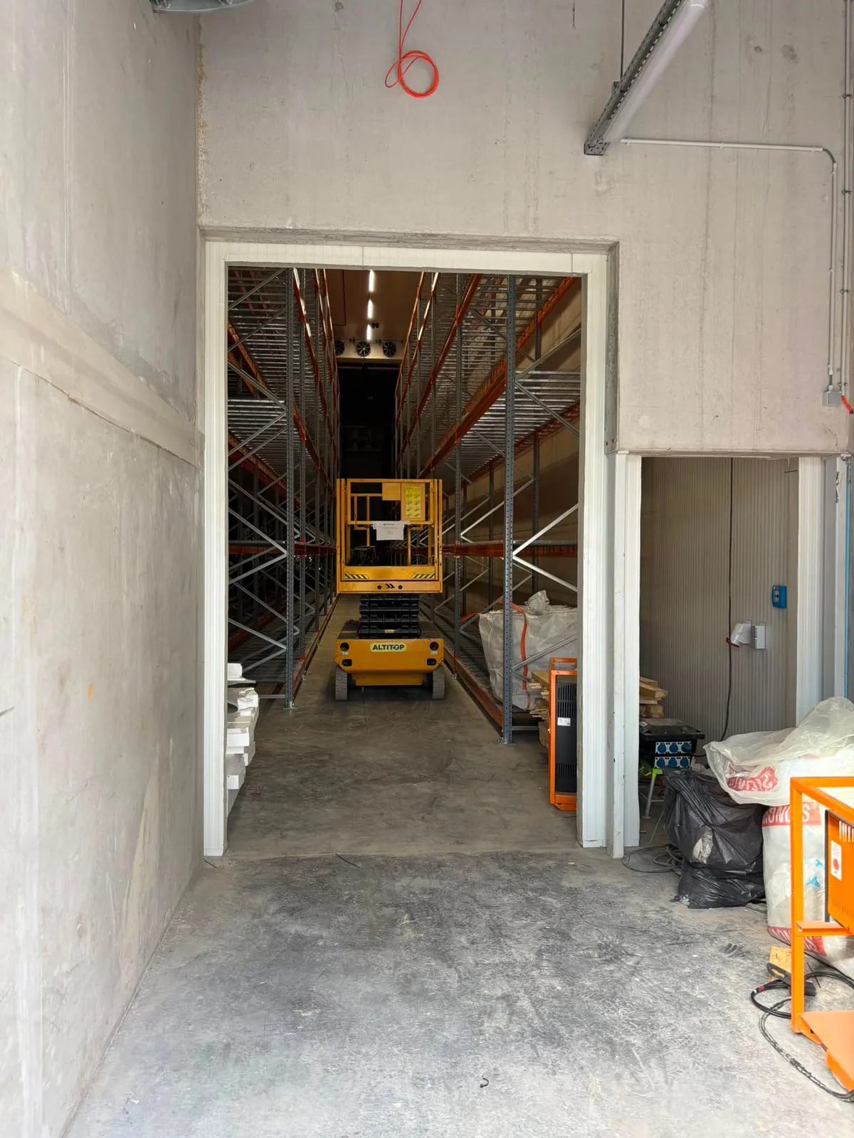 Gaaslegborden op de liggers van de palletstellingen, gezien vanuit de gang