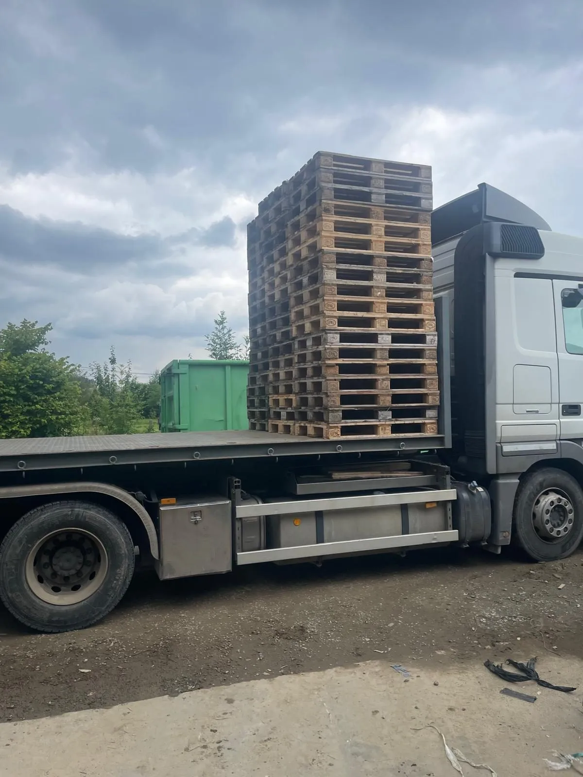 Vrachtwagen met een hoge stapel houten paletten op de laadbak