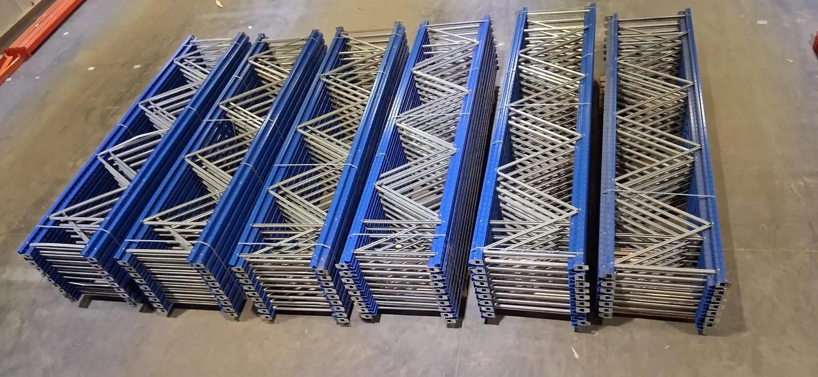 Blauwe staanders van tweedehands palletrekken naast elkaar op de vloer